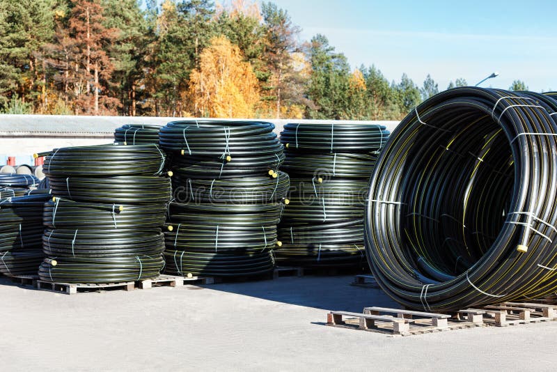 Stacks of Black Pvc Plastic Pipe Outdoors with Selective Focus Stock