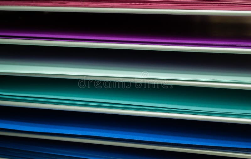 Stacks of colored paper in pink, lilac, and turquoise with blue royalty free stock image