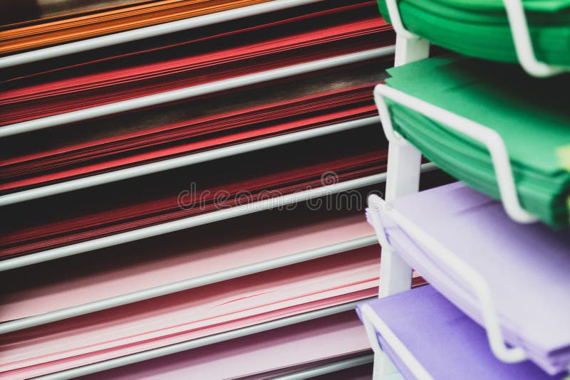 Stacks of colored paper in red, pink, lilac, and green stock image