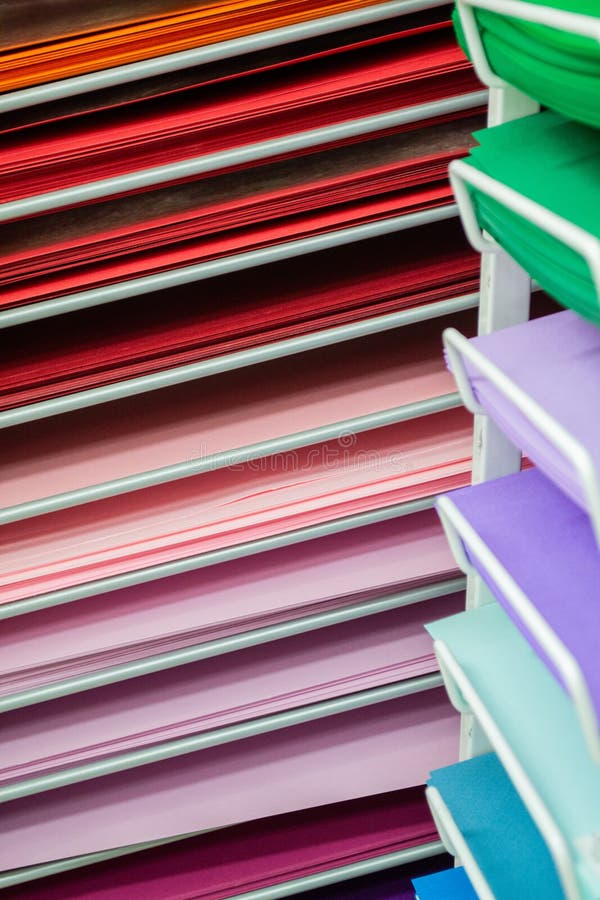 Stacks of colored paper in red, pink, lilac, and green with blue royalty free stock photos