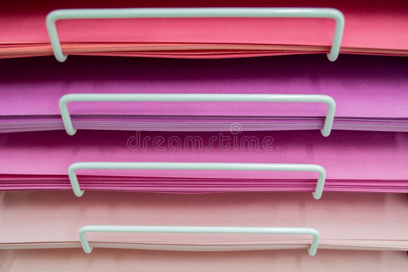 Stacks of colored paper in various shades of pink stock images