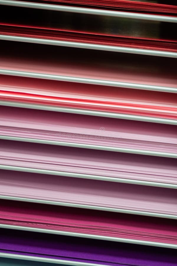 Stacks of colored paper in various shades of pink, red and purple royalty free stock photography
