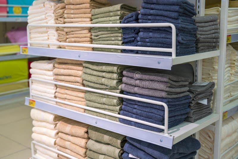 Stacks of colored towels on the shelves in supermarket royalty free stock photos