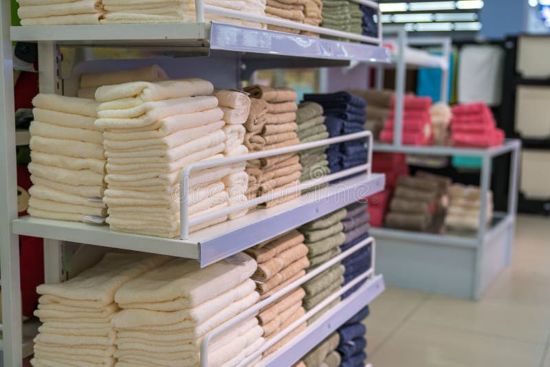 Stacks of colored towels on the shelves in supermarket stock image