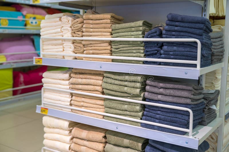 Stacks of colored towels on the shelves in supermarket royalty free stock image