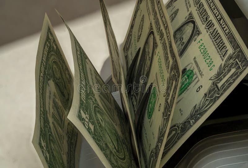 Cash being counted with a currency counting machine in a busy office royalty free stock image