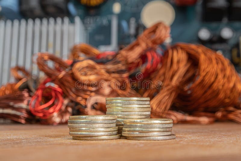 Stacks of Gold Coins on a Background of Copper and Electrical Waste