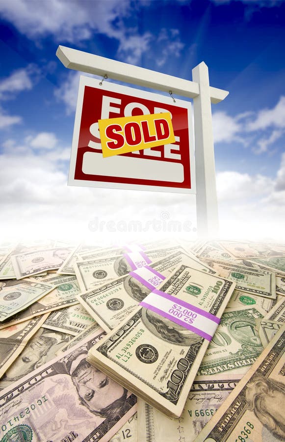 Stacks of Money Fading Off and Sold For Sale Real Estate Sign Against Blue Sky with Clouds. Stacks of Money Fading Off and Sold For Sale Real Estate Sign Against Blue Sky with Clouds.