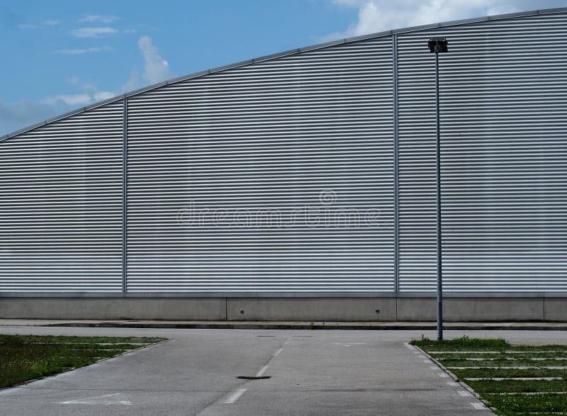 Stads- bakgrund f?r kopieringsutrymme Tom väg som är främst av en modern byggnad för aluminiumcladding, med halvcirkelformig form royaltyfri fotografi Stads- bakgrund f?r kopieringsutrymme Tom väg som är främst av en modern byggnad för aluminiumcladding, med halvcirkelformig form royaltyfri fotografi