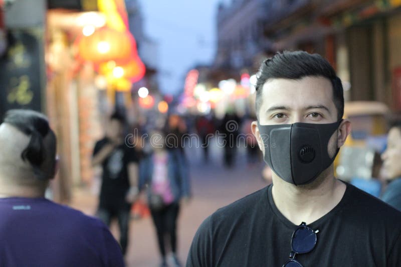 Stads- bild av den unga mannen med föroreningmaskeringen royaltyfri fotografi Stads- bild av den unga mannen med föroreningmaskeringen royaltyfri fotografi