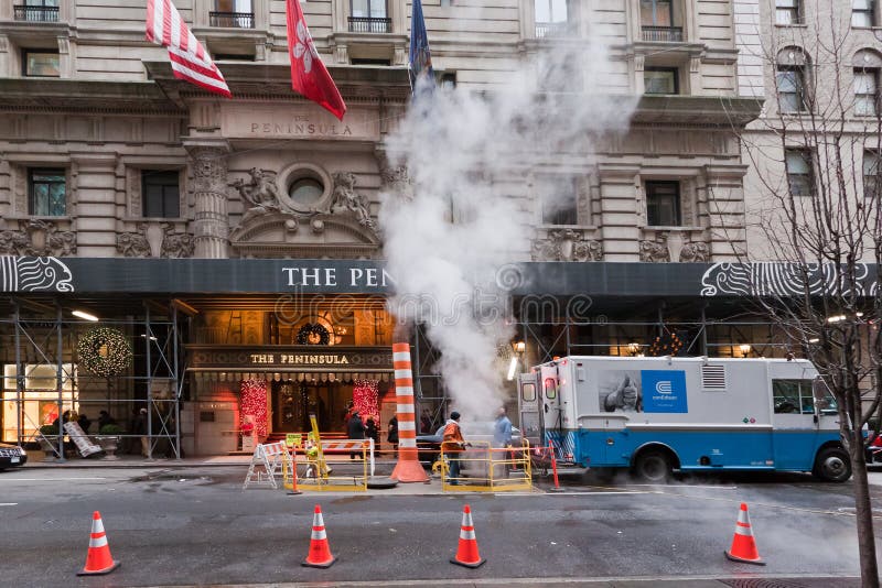 Workers on a street with white water smoke in front of the Peninsula Hotel. Manhattan Island, New York City, USA. Workers on a street with white water smoke in front of the Peninsula Hotel. Manhattan Island, New York City, USA.