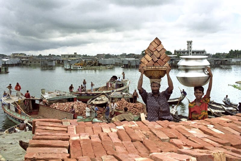 Stadsliv i Dhaka med arbetare, slumkvarteret och floden trafikerar arkivfoto Stadsliv i Dhaka med arbetare, slumkvarteret och floden trafikerar arkivfoto