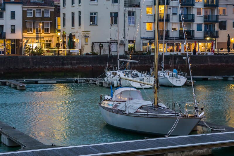 Stadtbild der Docks von Vlissingen, verziertes Boot mit Lichtern, populäre Stadt in Zeeland nachts, die Niederlande stockbild Stadtbild der Docks von Vlissingen, verziertes Boot mit Lichtern, populäre Stadt in Zeeland nachts, die Niederlande stockbild