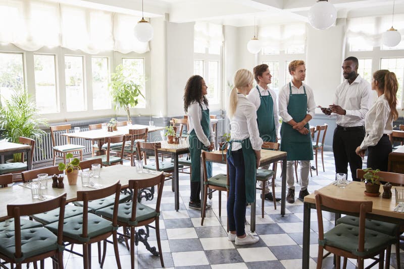 Staff Attending Team Meeting in Empty Dining Room Stock Photo Image
