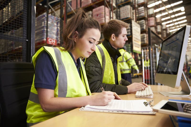 Staff managing warehouse logistics in an on-site office royalty free stock image
