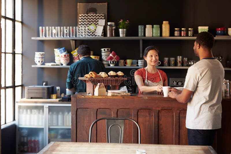 Staff Serving Customer In Busy Coffee Shop royalty free stock photo