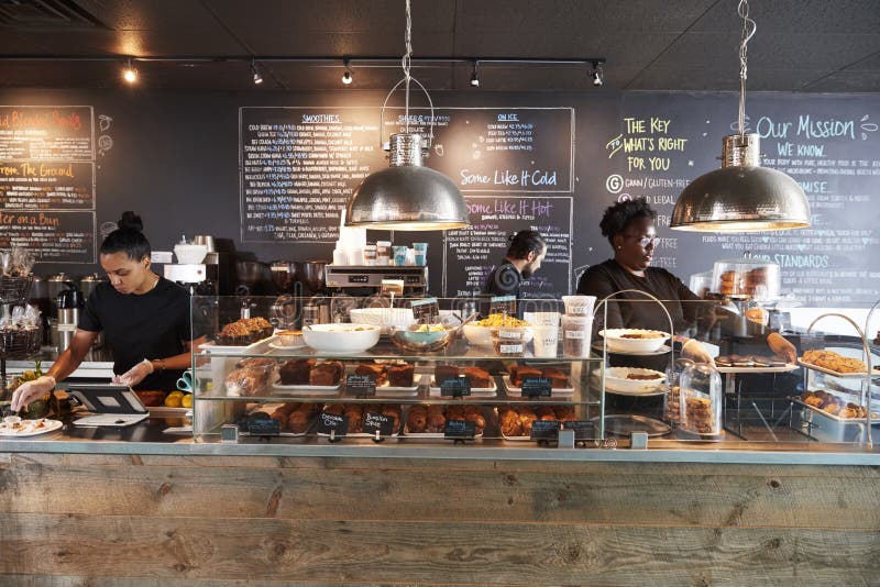 Staff Working Behind Counter In Busy Coffee Shop royalty free stock photo