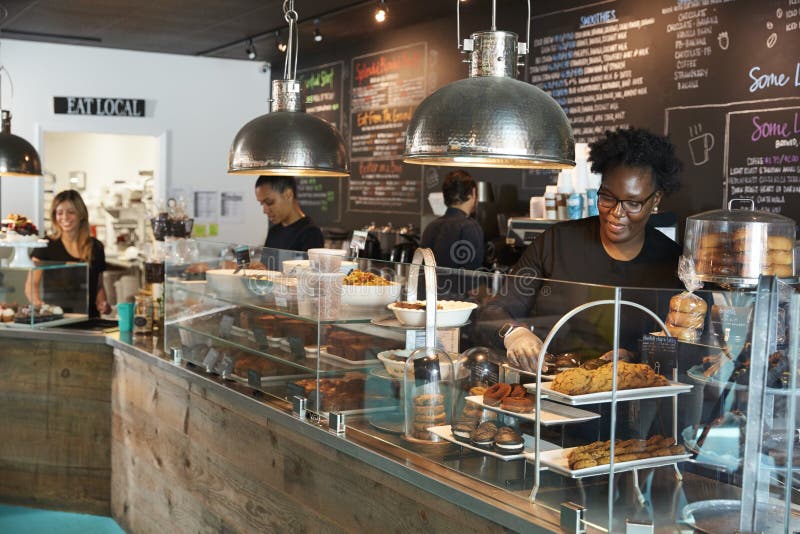 Staff Working Behind Counter In Busy Coffee Shop royalty free stock image