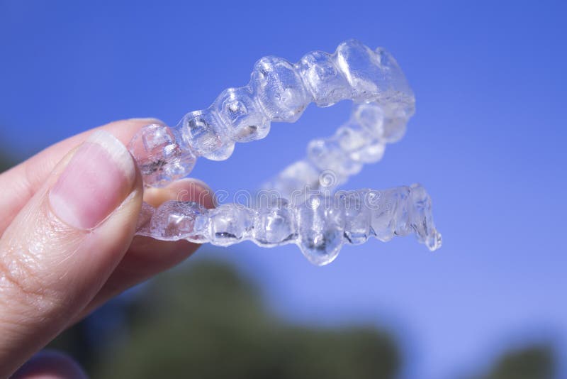 Staffe dentarie invisibili detenute da una donna fotografia stock libera da diritti Staffe dentarie invisibili detenute da una donna fotografia stock libera da diritti