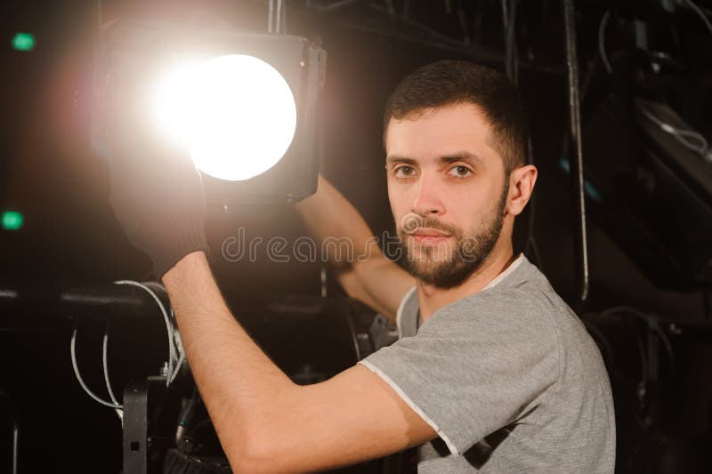 The stage worker sets up the lights.