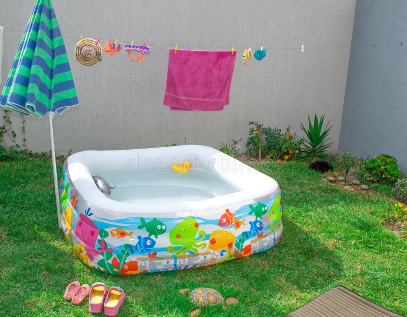 Stagno gonfiabile nel giardino, con un ombrello immagine stock libera da diritti Stagno gonfiabile nel giardino, con un ombrello immagine stock libera da diritti