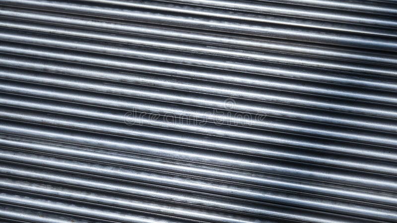 Stahlstäbe, parallel angeordnet, in einem industriellen Rahmen gebaut. Lange Stahlstäbe sind sorgfältig in parallelen Linien angeordnet, die ihre metallische Schere und ihren industriellen Zweck darstellen. Die Einstellung schlägt eine Baustelle vor, auf der diese Stäbe wahrscheinlich für die Verstärkung von Bauprojekten verwendet werden. ihre einheitliche Ausrichtung spiegelt die Präzision in der Fertigung wider, was die Bedeutung von Qualitätsmaterialien für die strukturelle Integrität unterstreicht