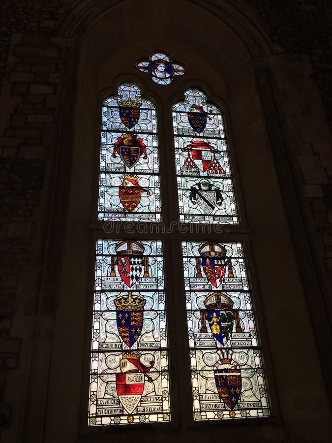 Stained glass window, with family crests and faint landscape in the background