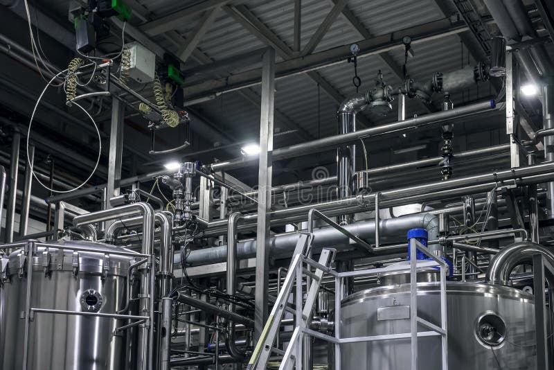 Stainless steel brewing equipment : large reservoirs or tanks and pipes in modern beer factory. Brewery production concept royalty free stock photography Stainless steel brewing equipment : large reservoirs or tanks and pipes in modern beer factory. Brewery production concept royalty free stock photography