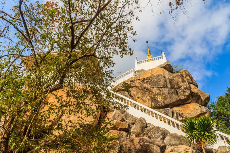 Stair way upward to the golden pagoda on the hill with blue sky background at Wat Khao Rup Chang or Temple of the Elephant Hill, o