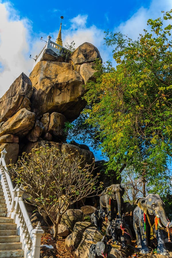 Stair way upward to the golden pagoda on the hill with blue sky background at Wat Khao Rup Chang or Temple of the Elephant Hill, o