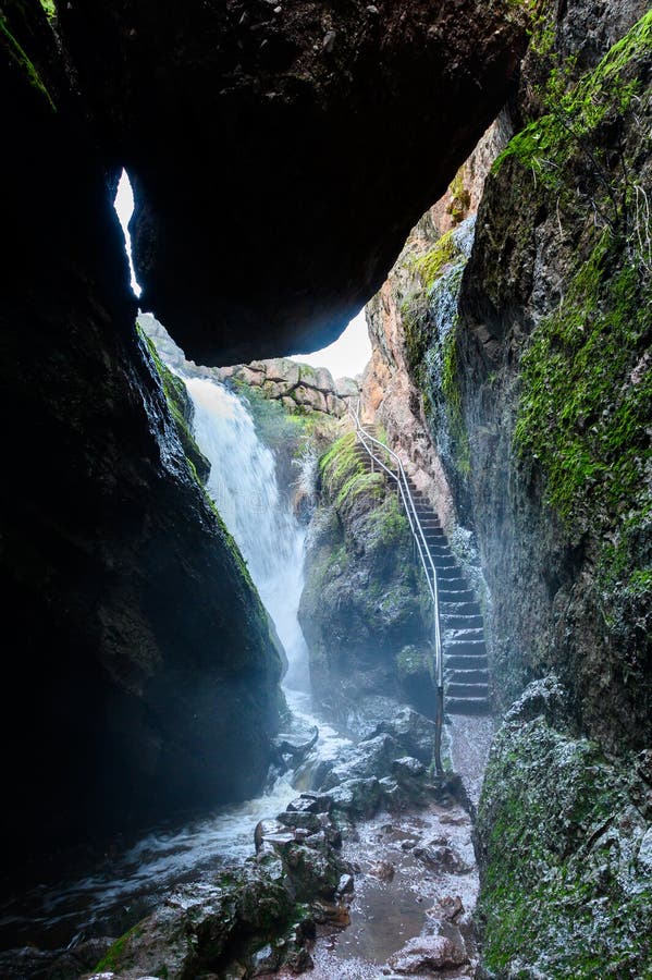 Staircase Climbs Alongside Cave Wall with waterfall