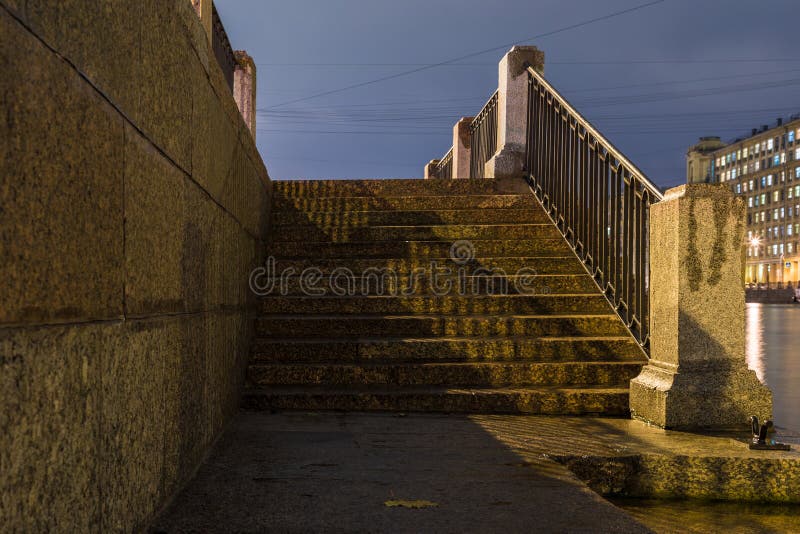 The stairway of the granite embankment of Neva, Fontanka or Moyka river in Saint Petersburg in the cloudy autumn evening stock photo The stairway of the granite embankment of Neva, Fontanka or Moyka river in Saint Petersburg in the cloudy autumn evening stock photo