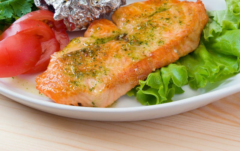 Stake from a salmon with vegetables. Closeup. stock photo