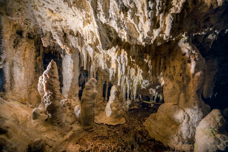 Stalaktity a stalagmity kvapľový kameň v demänovskej jaskyni slobody, slovensko, geologické útvary na pozadí