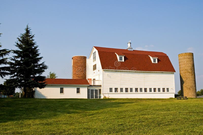 Classic barn with a red gambrel roof with two silos. Classic barn with a red gambrel roof with two silos