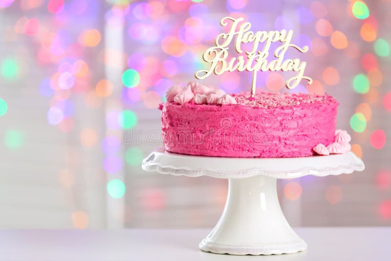 Stand with Delicious Birthday Cake on Table Against Blurred Lights