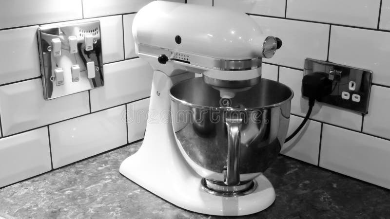 White kitchen machine and stand mixer on a wooden table in a bright design  apartment Stock Photo - Alamy