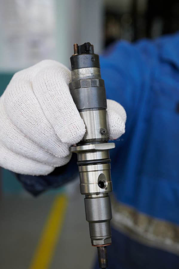 At the stand, the process of checking the operability and wear, the operational properties of the nozzle of a diesel internal combustion engine, close-up, car service