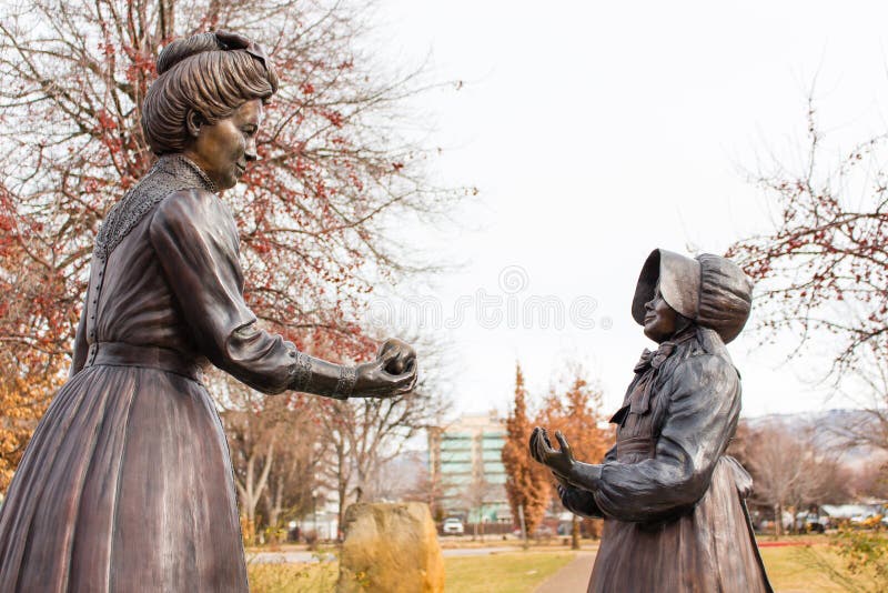 Standbeeld van een vrouw die een meisje een appel in Boise Rose Garden overhandigen stock afbeeldingen Standbeeld van een vrouw die een meisje een appel in Boise Rose Garden overhandigen stock afbeeldingen