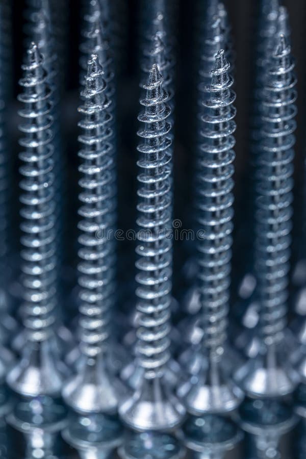 Standing Galvanized Selftapping Screws on a Mirror Surface Stock Photo