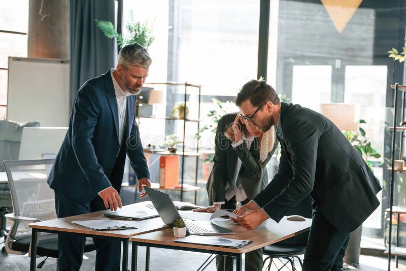 Standing by the Table. Group of Business People are Working in the