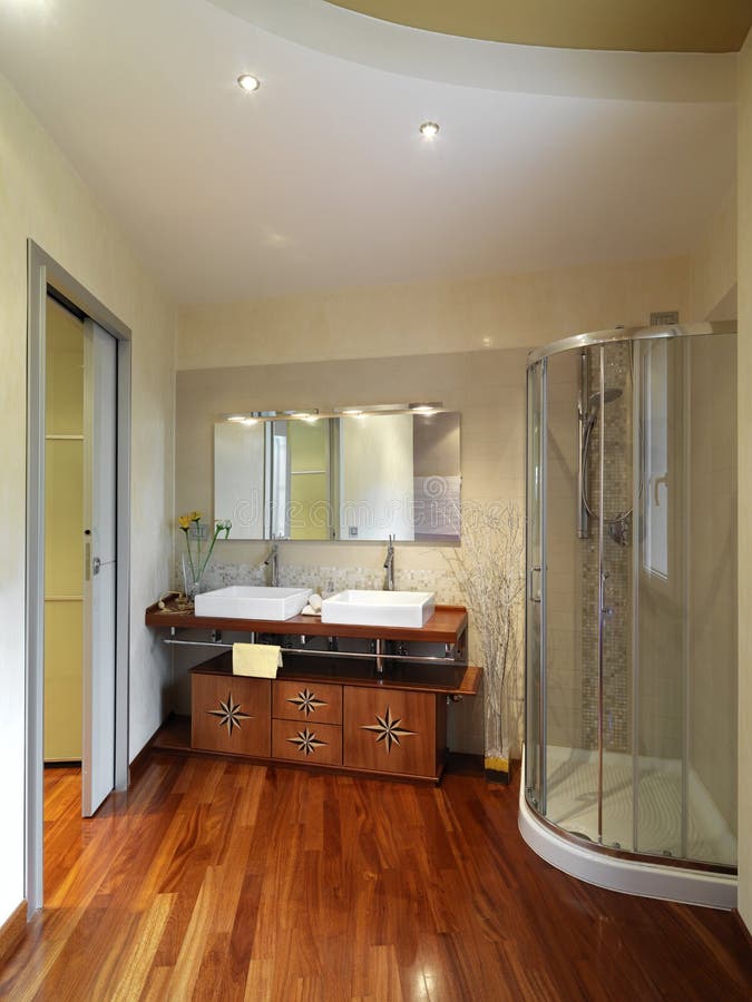 Modern and luxurious bathroom with wood floor and wood furniture near the shower cubicle. Modern and luxurious bathroom with wood floor and wood furniture near the shower cubicle