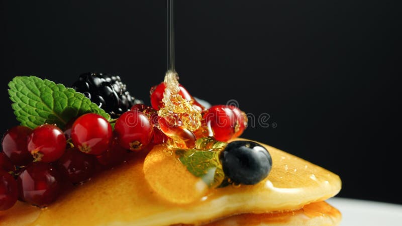 Stapel frische flaumige Pfannkuchen verziert auf die Oberseite mit Waldbeeren auf Platte und strömendem Honigsirup Köstlich, gesu lizenzfreies stockbild Stapel frische flaumige Pfannkuchen verziert auf die Oberseite mit Waldbeeren auf Platte und strömendem Honigsirup Köstlich, gesu lizenzfreies stockbild