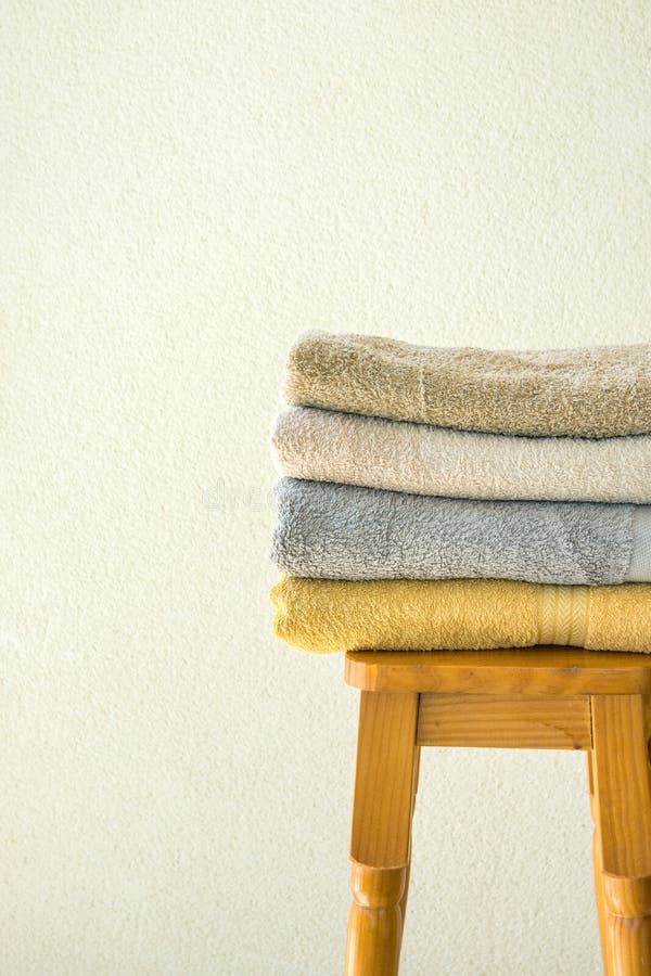 Stapel schone gevouwen badstofhanddoeken op de houten hoge achtergrond van de kruk witte muur Laundry spa het concept van de well stock foto Stapel schone gevouwen badstofhanddoeken op de houten hoge achtergrond van de kruk witte muur Laundry spa het concept van de well stock foto