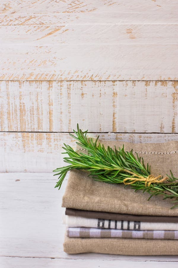 Stapel van gestapelde gevouwen keukenhanddoeken op witte plank houten achtergrond, rozemarijntakje, rustieke minimalistic stijl stock foto's Stapel van gestapelde gevouwen keukenhanddoeken op witte plank houten achtergrond, rozemarijntakje, rustieke minimalistic stijl stock foto's
