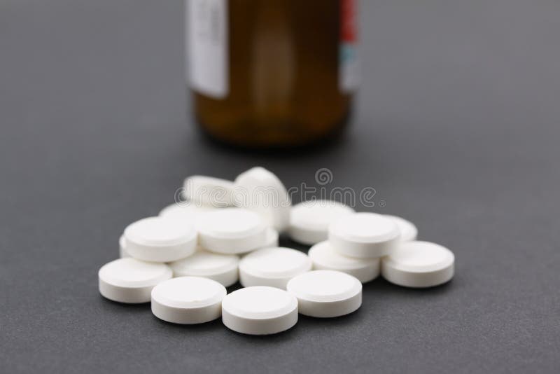 Stapel van witte pillen met bruine pillenfles in backgroundllfles die vitaminen of verslaving illustreren aan drugs sluit omhoog royalty-vrije stock afbeeldingen Stapel van witte pillen met bruine pillenfles in backgroundllfles die vitaminen of verslaving illustreren aan drugs sluit omhoog royalty-vrije stock afbeeldingen