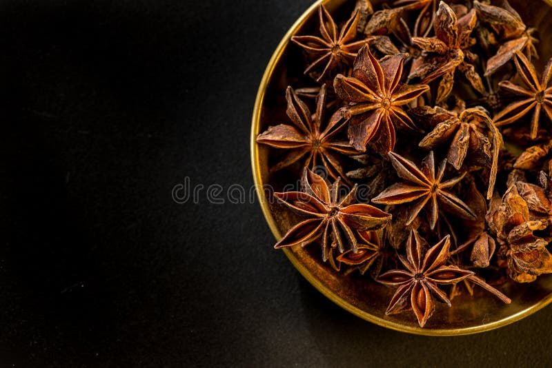 Star shape anis seeds in bowl on black slate stock photos Star shape anis seeds in bowl on black slate stock photos