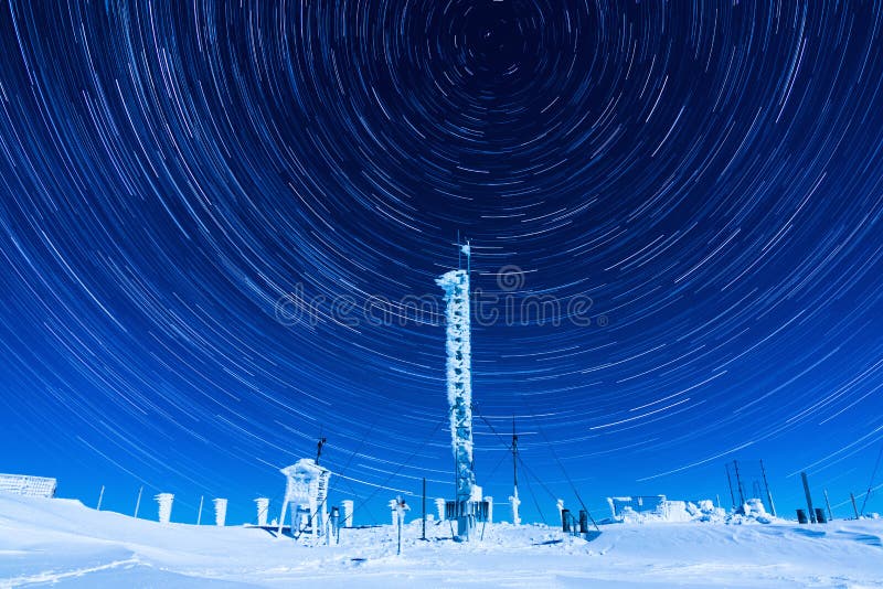 Beautiful star trails on the night sky during a clear winter night while spending time on top of a mountain