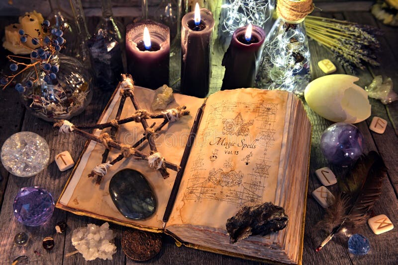 Stara czarownicy książka z pentagramem, czarnymi świeczkami, kryształami i rytuałem, protestuje