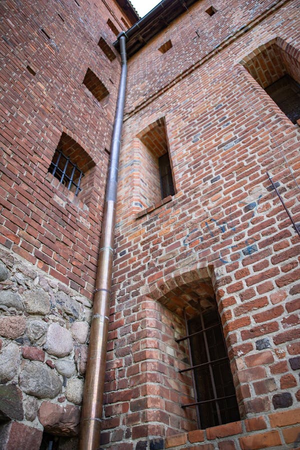 Stara groszaka odcieku rynna w ceglanym domu Instalacja kt?ra drenuje wod? od dachu obraz stock Stara groszaka odcieku rynna w ceglanym domu Instalacja kt?ra drenuje wod? od dachu obraz stock